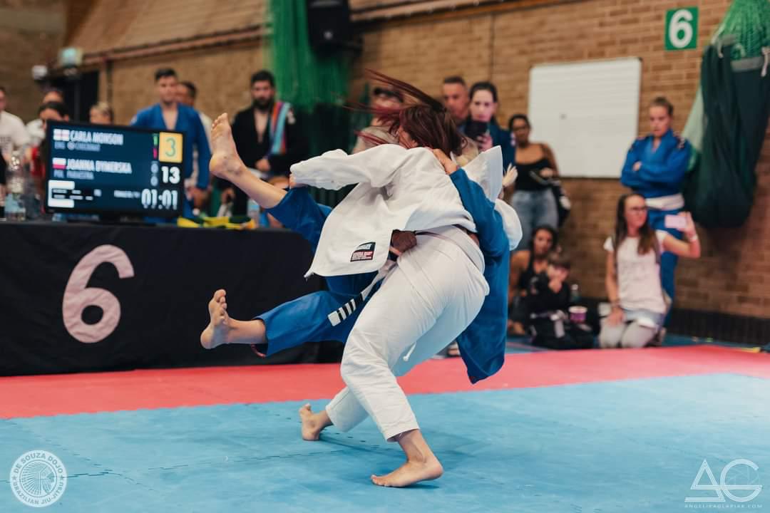 Two athletes in white and blue gis during a BJJ match
