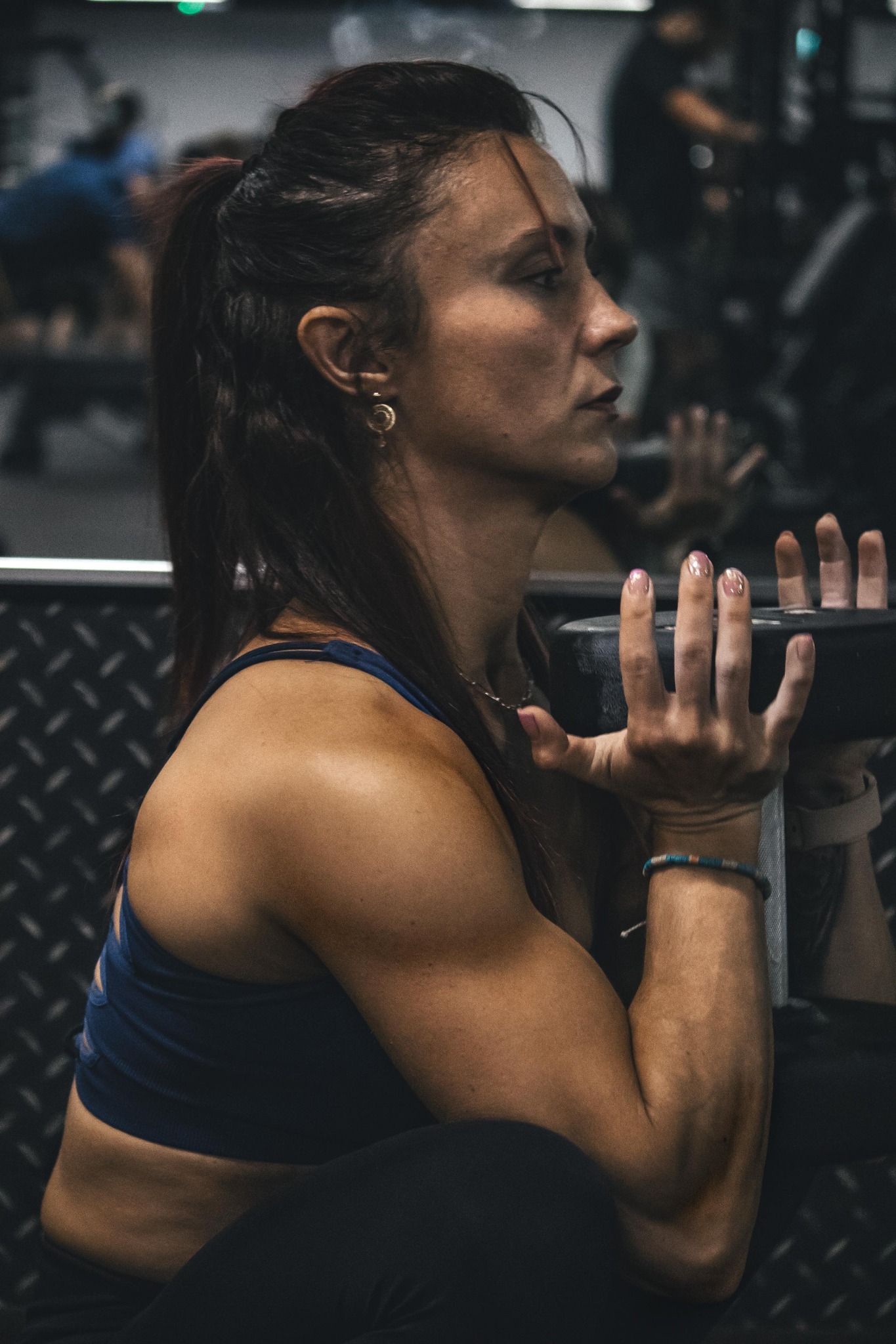 Joanna holding a weight at chest height during strength training